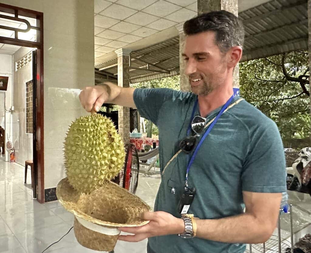 Jared Dillingham holding a durian in Vietnam