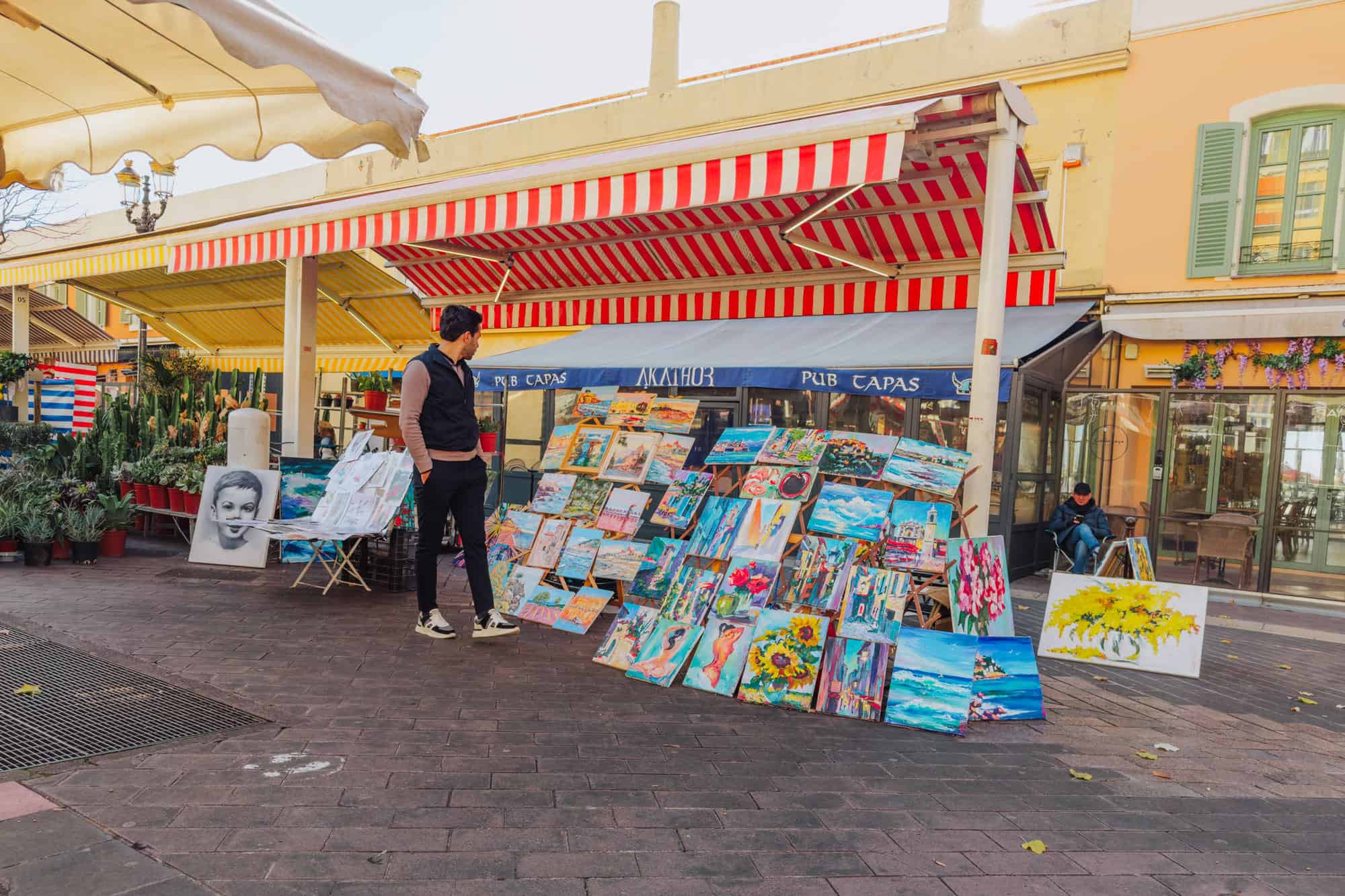 Artist selling paintings at a market in Nice, France