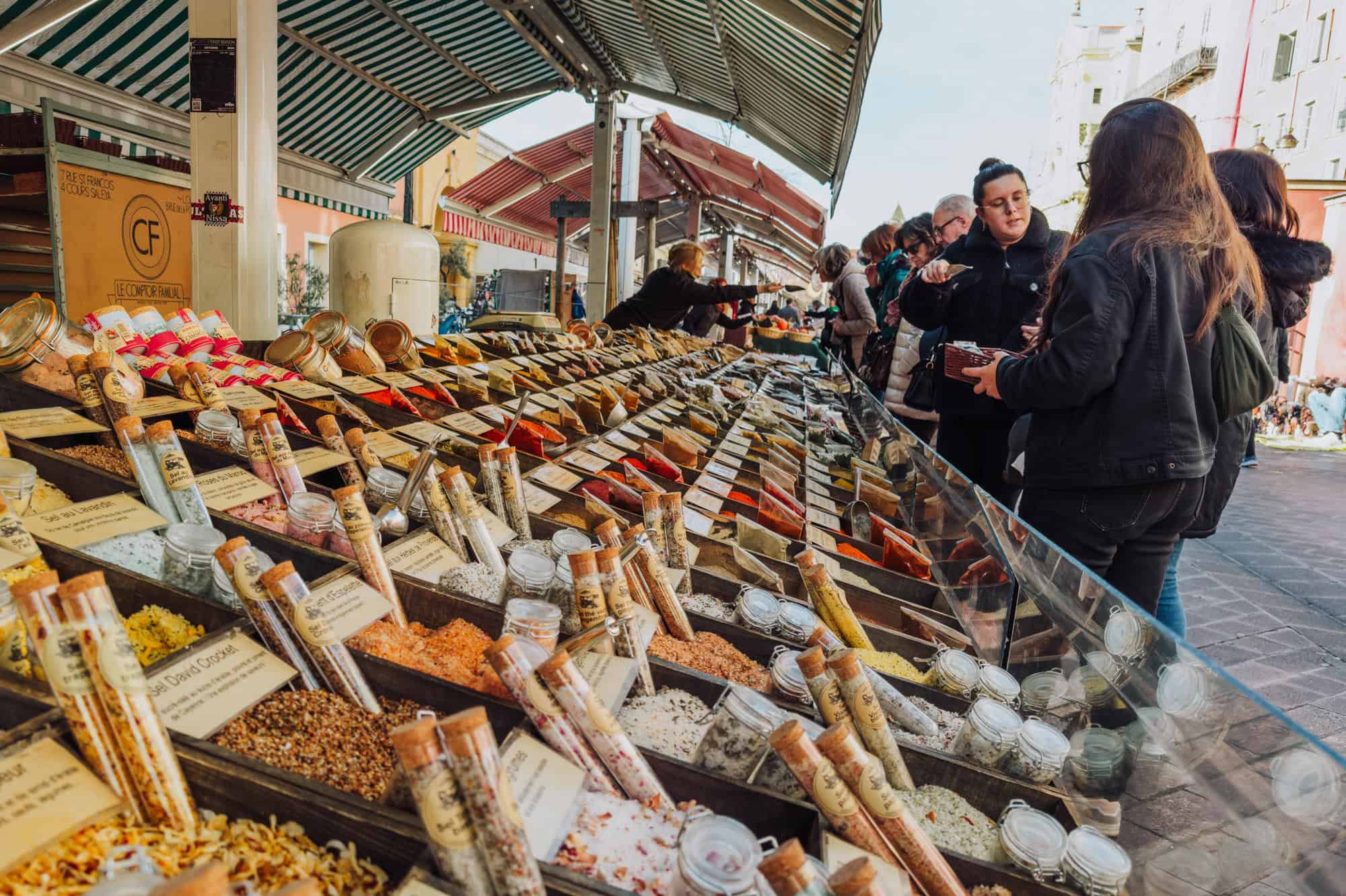 People shopping for spices in winter at a market in Nice, France