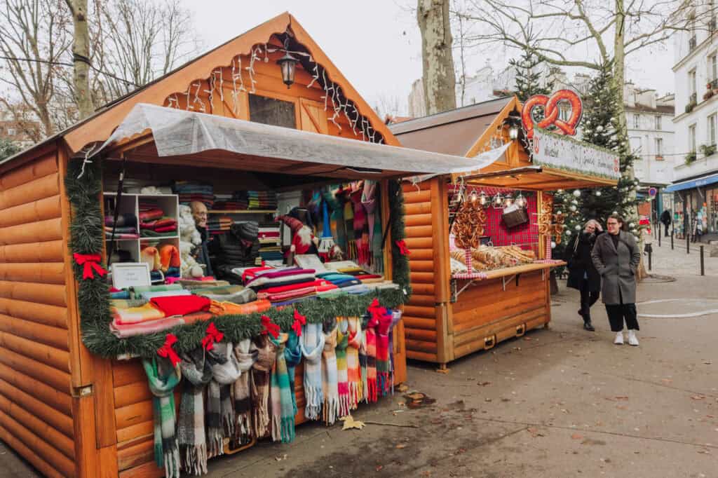 A Christmas Market in Paris, near the Abbesses Metro station, selling scarves and food.