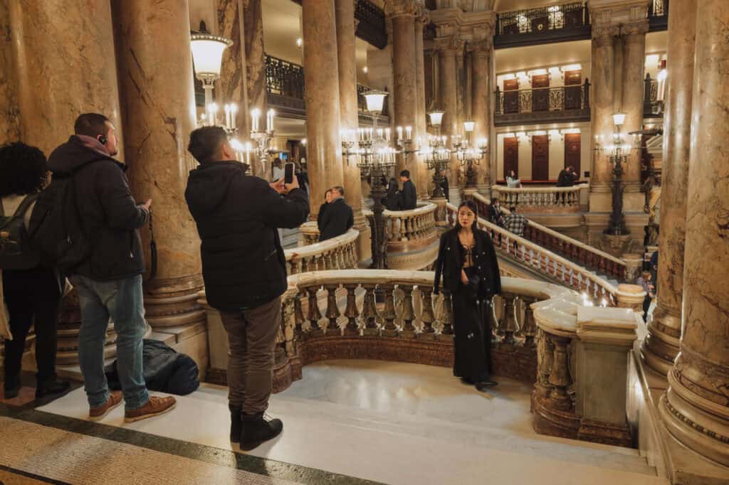 People posing for photos inside Palais Garnier in winter