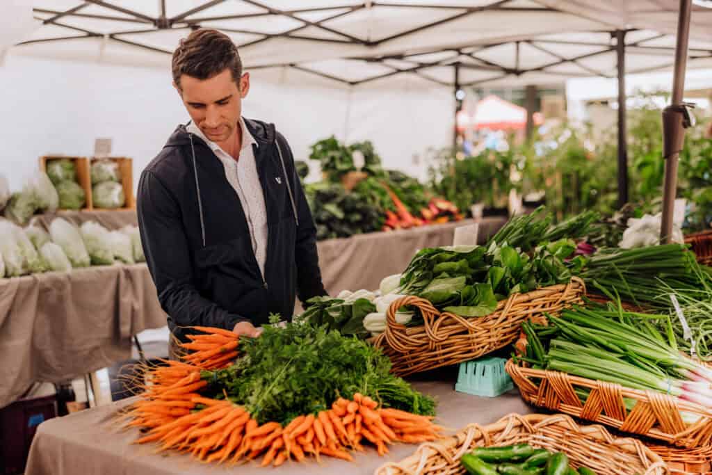 Jared Dillingham looking at produce at the Vancouver Farmers Market