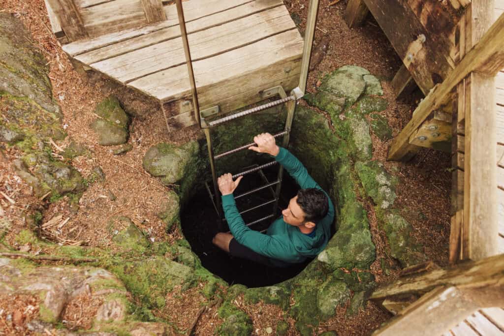 Climbing down into a lava tube at Trail of Two Forests in Washington
