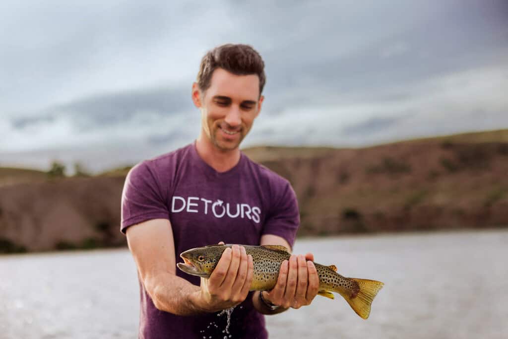 Jared Dillingham, holding a trout caught fly fishing in Montana