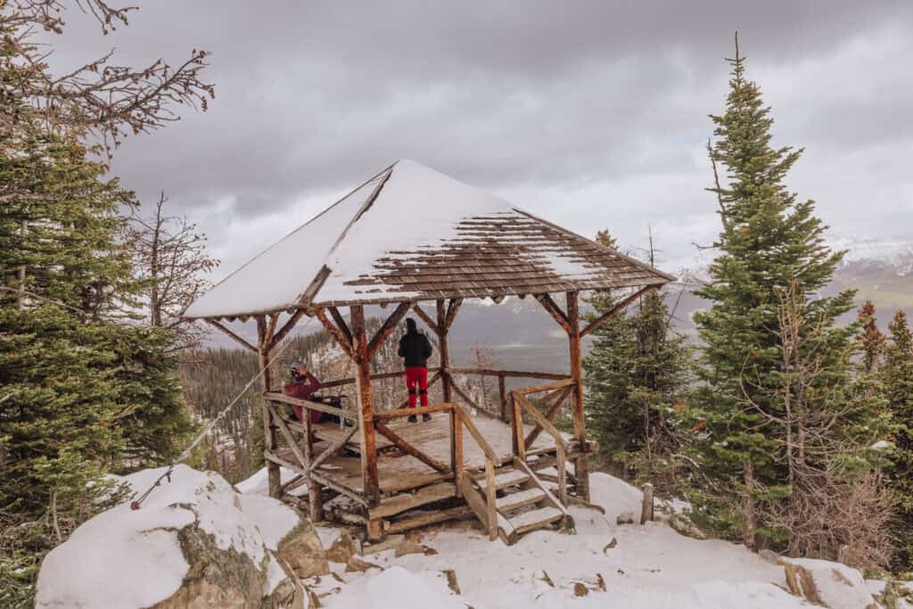 Rustic wooden lookout gazebo in snowy mountain forest, scenic views, outdoor adventure with Jared's Detours.