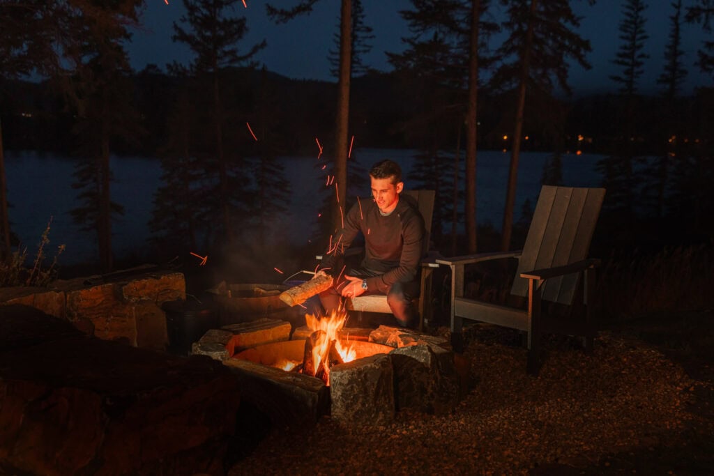 Jared Dillingham making a bonfire lakeside at the Fairmont Jasper Park Lodge in autumn