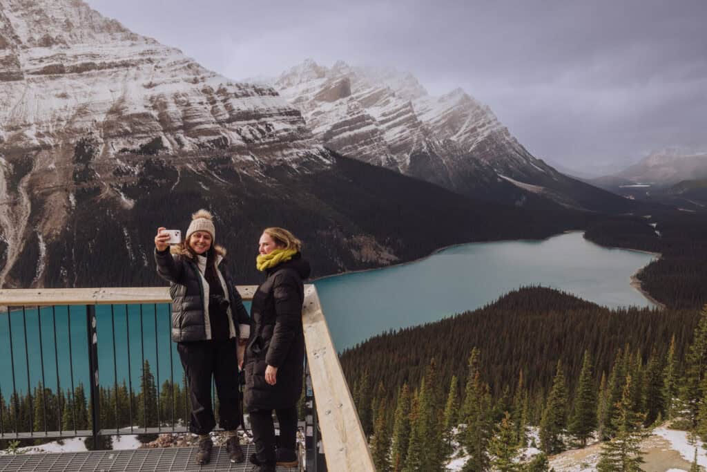 People taking photos at the Peyto Lake viewpoint