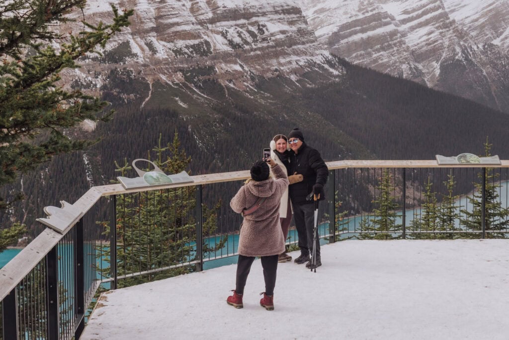People taking photos from the viewing platform above Peyto Lake