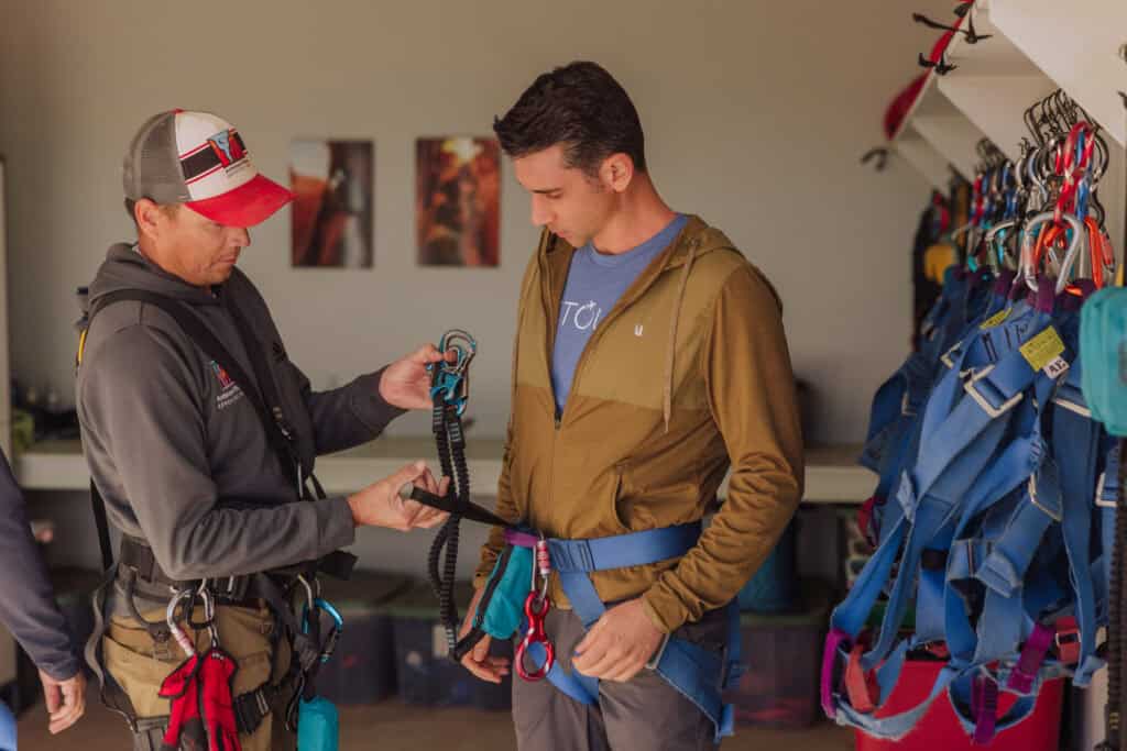 Jared Dillingham gearing up to rappel into Antelope Canyon with Theo Martin
