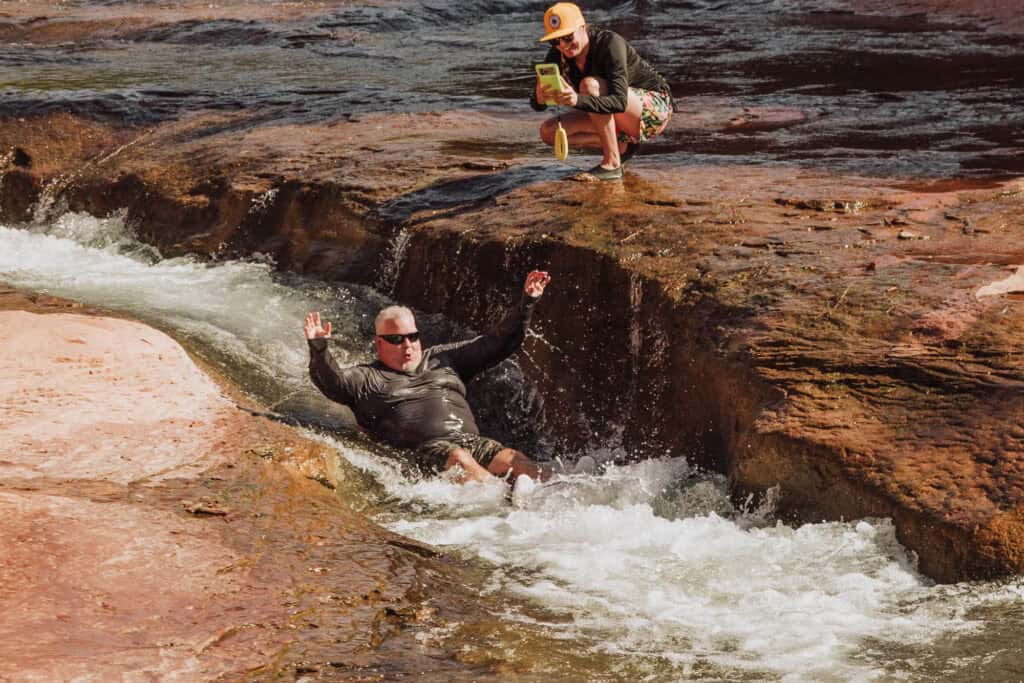 A man sliding down the natural chute at Slide Rock
