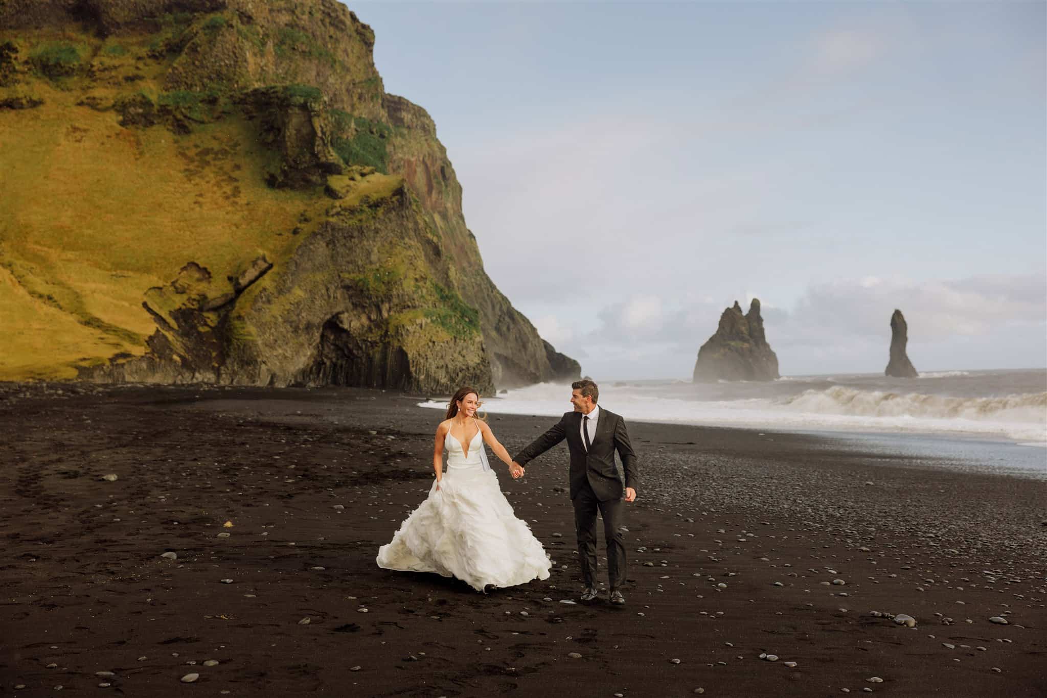 A bride and groom on Iceland's black sand beach, Reynisfjara, which eroded