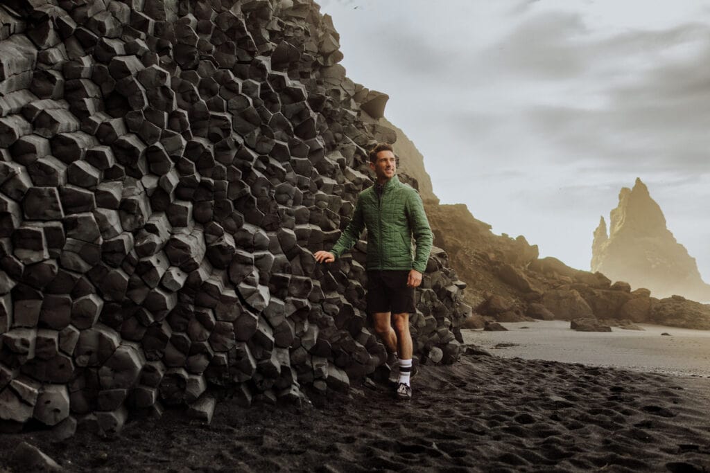Jared Dillingham walking along the black sand beach, Reynisfjara, on southern Iceland, which eroded