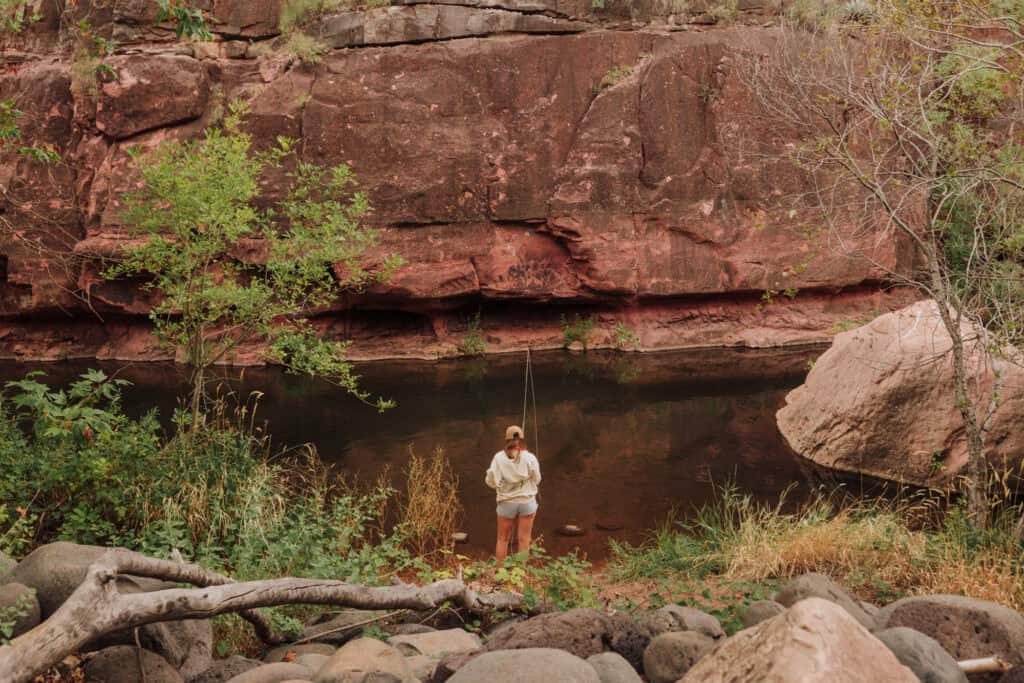 A woman fishing in Oak Creek, under Midgley Bridge in Sedona