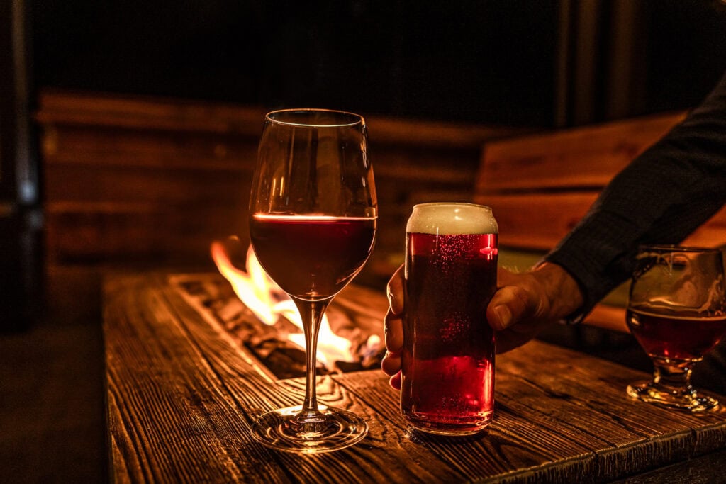 A glass of sangiovese and an IPA by the fire on Naughty Oak's patio