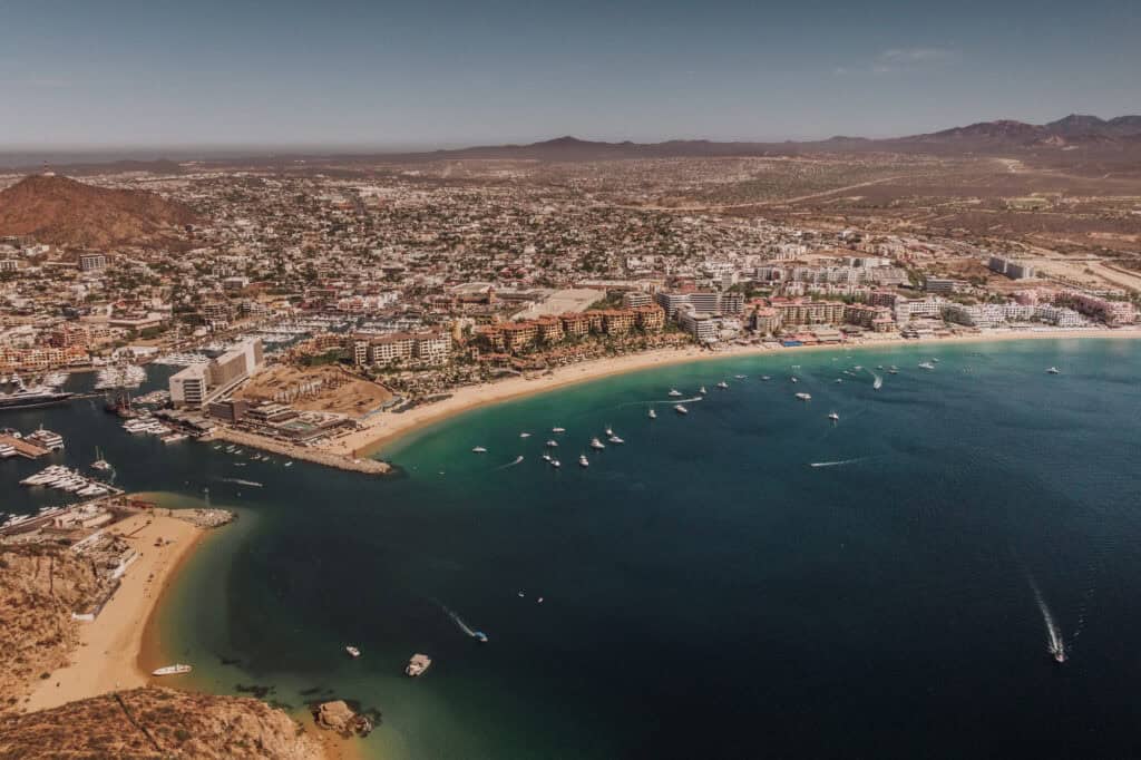 An aerial drone view of Cabo San Lucas Mexico, the beautiful blue water, and the beach