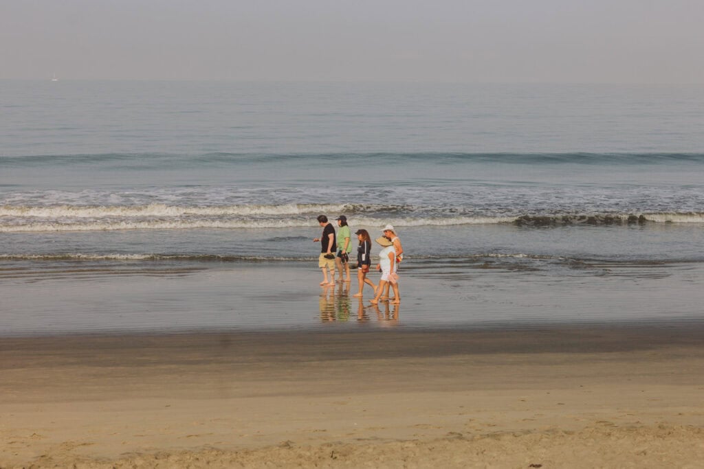 Guests at Marival Distinct walking along the beach