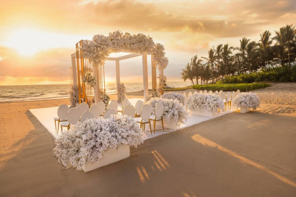 A wedding setup at sunset on the beach near Marival Distinct's Mozzamare Beach Club